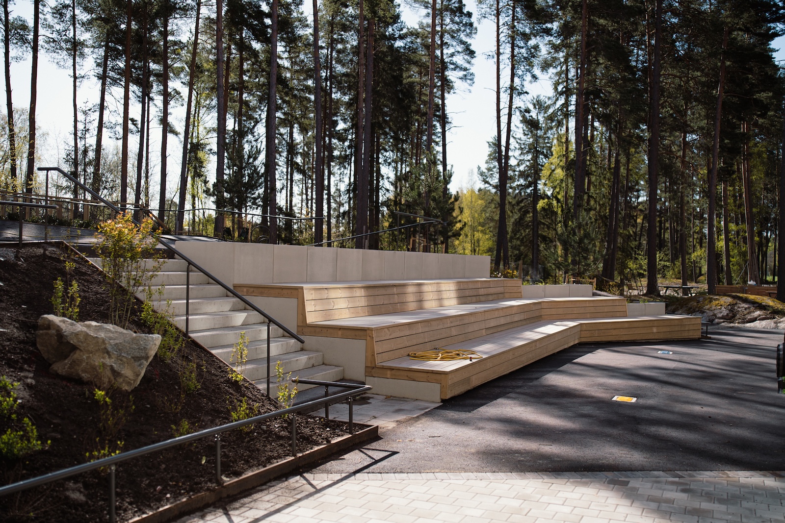 037-Etage Plattsättning, finplanering och markarbete av uteplats av Markax, Gottsundaskolan i Uppsala. Innefatta stenmur och sittbänk, samt asfaltering och VA-arbete